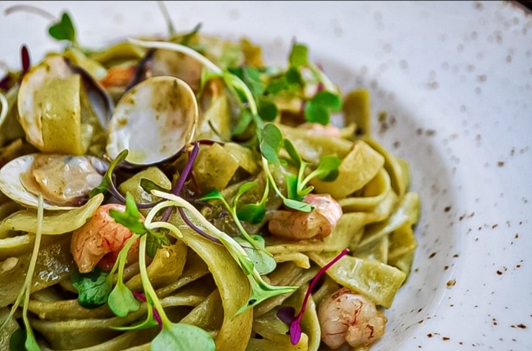 Fotografía gastronómica de pasta fresca con almejas y brotes, por Oscar Leal